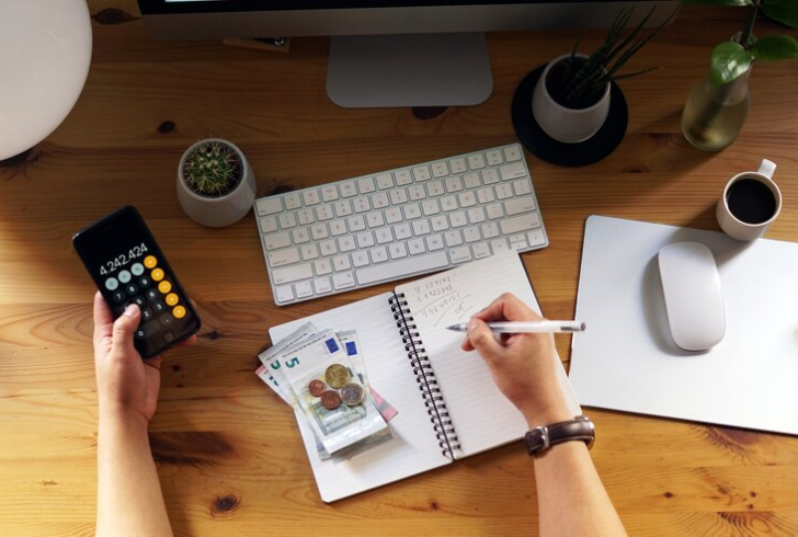Person budgeting with notebook and calculator