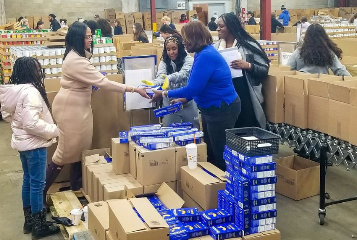 Food bank workers giving food to needy people