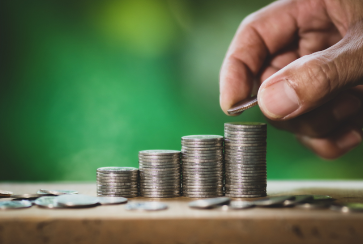 Hands placing coins on growing stacks.