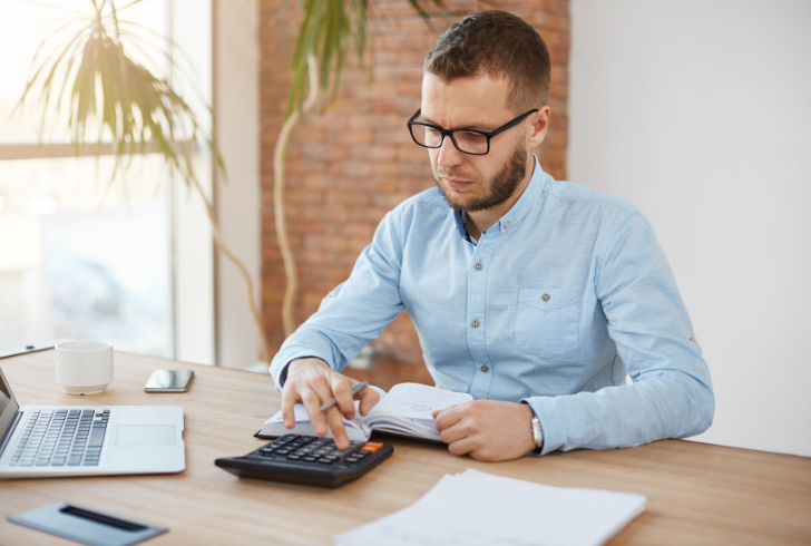 Person reviewing expenses with calculator