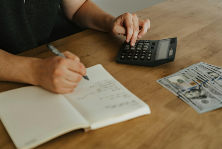 Person planning budget with calculator